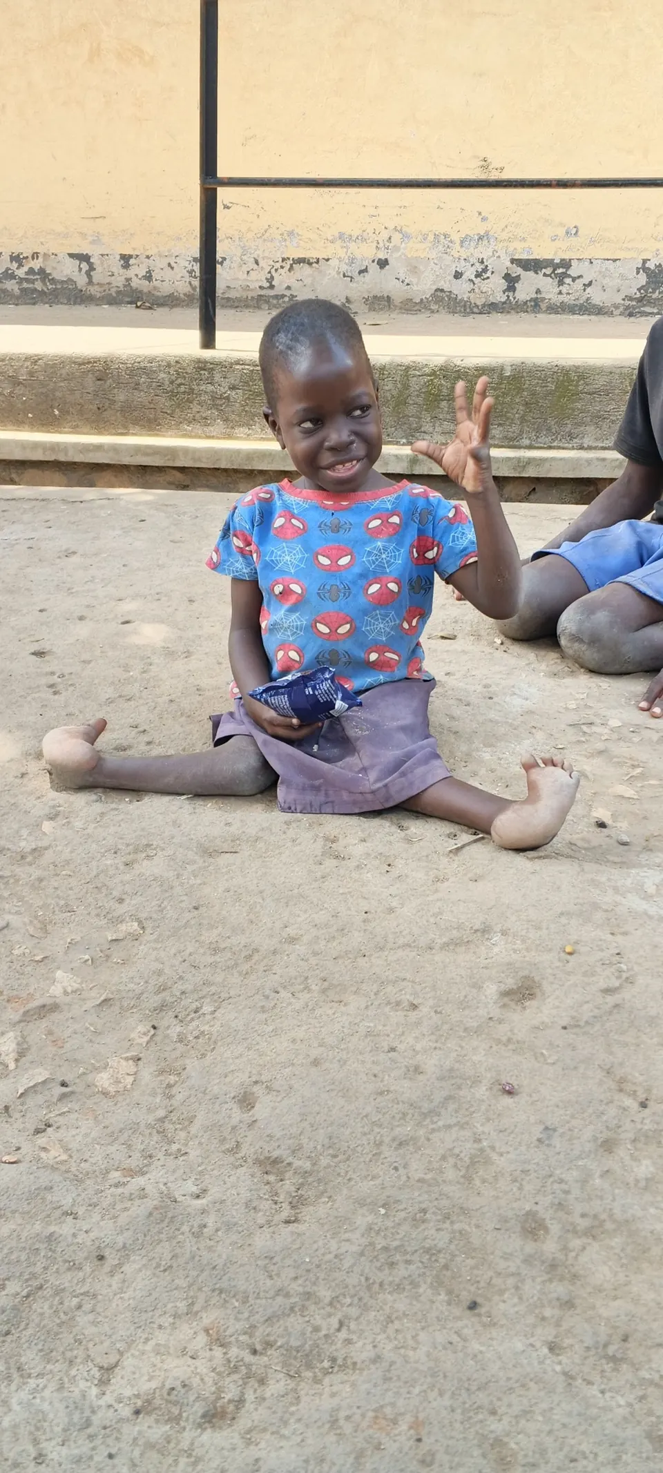 Lachendes Kind aus dem Mukono District winkt in die Kamera